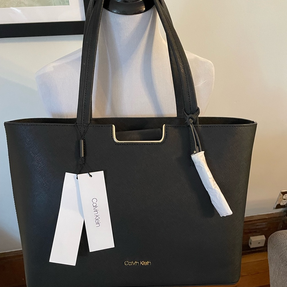 Brand new with tags leather Calvin Klein bag. Black with gold. 15”x10”